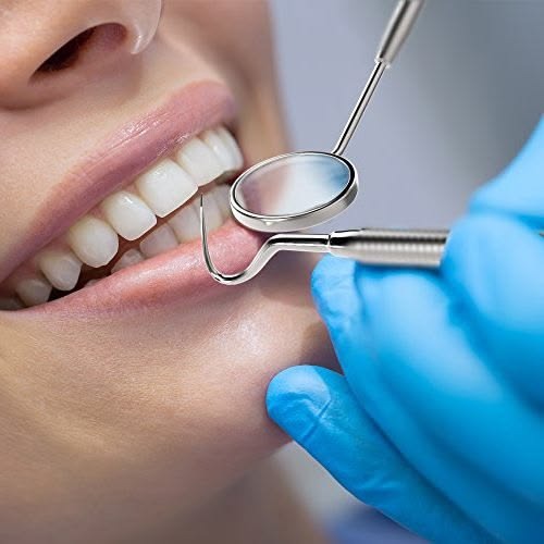 Dental professional examining a patient's teeth for restorative treatment